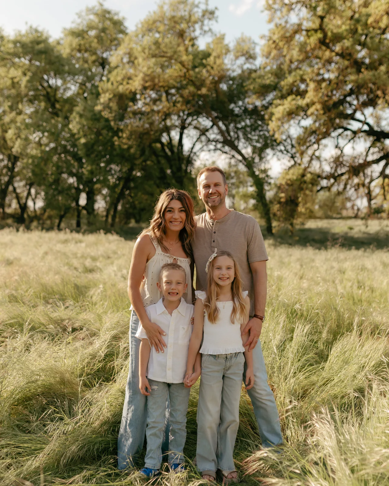 Dr. Becker and his family standing together in a field of tall grass